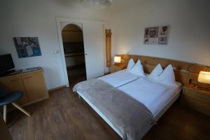 een slaapkamer met een bed en een bureau met 2 lampen bij Residence Rebgut in Tesimo