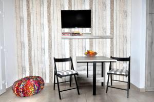 a dining room with a table and chairs and a tv at On The Beach in Ierapetra
