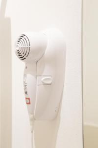 a white hair dryer hanging on a wall at SoleLuna Fiera 6 Rooms in Bologna