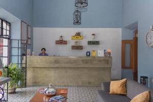 a woman standing behind a counter in a living room at Hotel La Casona de Don Jorge in Colima