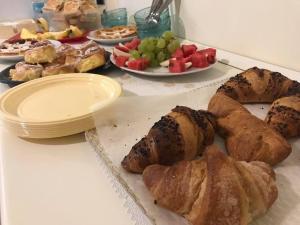 a table with plates of pastries and plates of fruit at Le Dolci Notti in Scilla