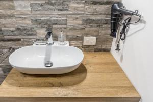 a white sink on a wooden counter in a bathroom at CaMagnolia Apartment in Montegrotto Terme