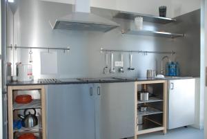 a kitchen with white cabinets and a counter top at Albergue Xabarín in Abadín