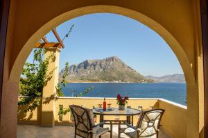 einen Tisch und Stühle auf einem Balkon mit Meerblick in der Unterkunft Amphitrite in Myrties