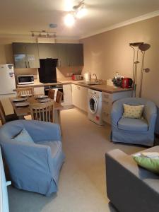 een keuken en een woonkamer met een bank en stoelen bij The Pally - behind 13 Palace Road, Kirkwall, Orkney - STL OR00122F in Kirkwall