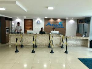 a group of people standing at a counter in a restaurant at Anjos Praia Hotel in João Pessoa