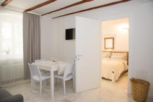 um quarto branco com uma mesa e uma cama em Residenza Romantica em Riva del Garda