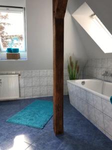 La salle de bains est pourvue d'une baignoire et d'une fenêtre. dans l'établissement Liebevoll eingerichtete Ferienwohnung im DG, à Zwenkau