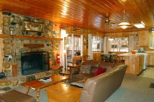 a living room with a stone fireplace and leather furniture at 28 Raccoon's End in Wawona