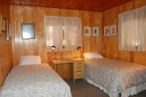 a bedroom with two beds and a desk with a window at 28 Raccoon's End in Wawona