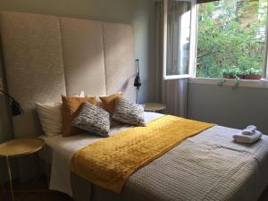 a bedroom with a bed with a yellow blanket and a window at Four Seasons Apartment in Athens