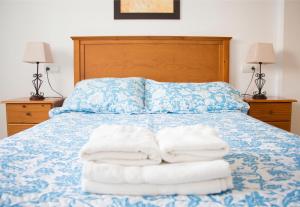 a bed with two towels sitting on top of it at Apartamentos Turísticos Fercomar in Nerja