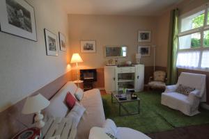 a living room with a white couch and chairs at La Chevalerie in Bléré