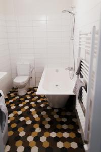 a bathroom with a toilet and a tub and a sink at New, modern apartment near Riga center in Riga