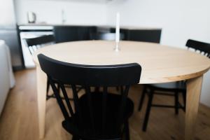 a wooden table with black chairs around it at New, modern apartment near Riga center in Rīga +10 photos