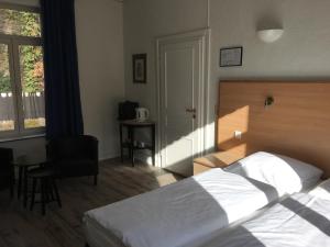 1 dormitorio con cama, escritorio y silla en Parkhotel Villa des Effats Vielsalm, en Vielsalm