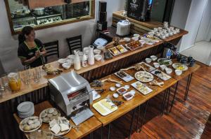 a woman standing behind a table with food on it at Hotel Vendaval in Puerto Natales