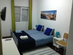 a bedroom with a bed with blue sheets and blue pillows at Palm Guesthouse B&B Rooms in Cascais
