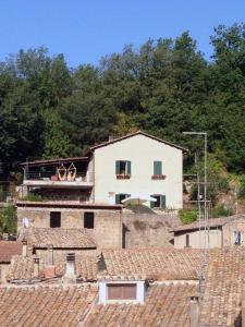 duży biały dom na wzgórzu z dachami w obiekcie Casa Belvedere w mieście Mazzano Romano