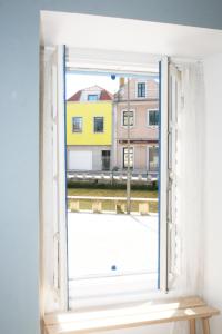 una ventana abierta con vistas a los edificios en Casa do Mercado, en Aveiro