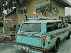 Un coche oxidado con una tabla de surf encima. en Pennwood Motor Lodge, en Sebastian