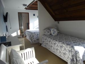 a bedroom with two beds and a table and chairs at Oak Lodge in Greymouth
