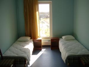 two beds in a room with a window at Sports Centre Haapsalu in Haapsalu +18 photos
