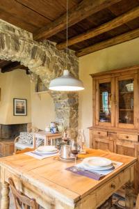 una mesa de madera con platos y copas de vino. en Casa Dafne, en Bracelli