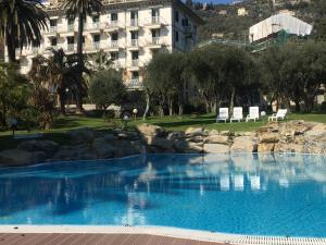 a large blue swimming pool with a building in the background at Casa Chicca Free Parking in Genova