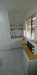 una cocina con fregadero y microondas en una encimera en Humewood Home Stay, en Port Elizabeth