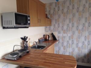 a kitchen with a sink and a microwave at Kevara Self-Catering in Finstown