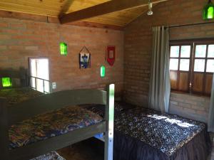 two bunk beds in a room with a brick wall at Chalé Ibiti in Conceição da Ibitipoca +2 photos