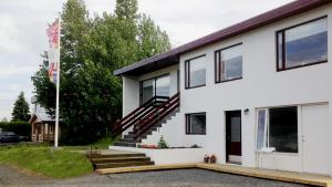 a white house with a staircase on it at Natura Apartments in Laugar