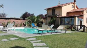 a house with a swimming pool with chairs and a house at Villa Iriscortona in Cortona