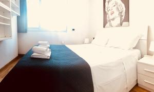 ローマにあるGiulio Cesare luxury apartmentのベッドルーム1室(白い大型ベッド1台、青い敷物のタオル付)