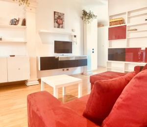 ローマにあるGiulio Cesare luxury apartmentのリビングルーム(赤いソファ、テーブル付)