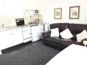 a living room with a couch and a kitchen at Springfield Holiday Apartments in Skegness