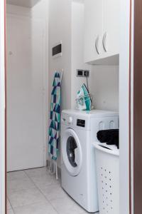 a white laundry room with a washer and dryer at Apartment Lapad Beach in Dubrovnik