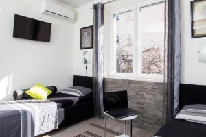 a bedroom with a black couch and a window at Apartment Lapad Beach in Dubrovnik
