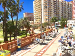 un grupo de personas sentadas en mesas en un parque en Puerto Marina, en Benalmádena