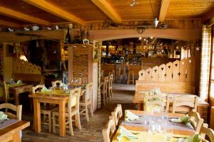 ein Restaurant mit Holztischen und -stühlen und einer Bar in der Unterkunft La Mollinière in Notre-Dame-de-Bellecombe