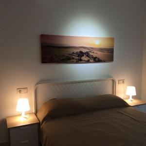 トレビエハにあるTorrevieja Playa Locosのベッドルーム1室(ベッド1台、テーブルにランプ2つ付)