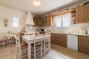 a kitchen with wooden cabinets and a white table at Villino Guest House in Akrotiri