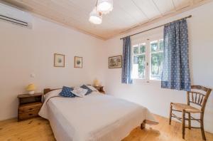 a bedroom with a bed and a chair and a window at Villino Guest House in Akrotiri