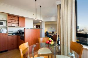 a kitchen with a glass table with a bowl of fruit on it at B-aparthotel Ambiorix in Brussels