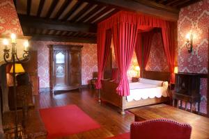 una camera con letto con tenda rossa di Hostellerie du Vieux Pérouges a Pérouges