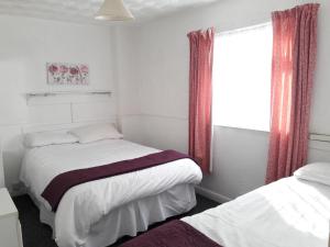 a bedroom with two beds and a window at Springfield Holiday Apartments in Skegness