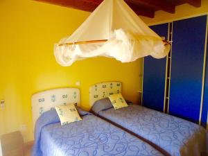 a bedroom with two beds and an umbrella at Villa LES TILILIS - BELLE VILLA DE 300 M2 SITUEE AU CALME AVEC GRANDE PISCINE ET VUE MONTAGNE in Petit-Bourg
