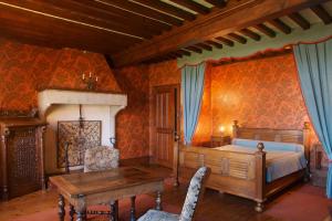 una camera con letto, scrivania e tavolo di Hostellerie du Vieux Pérouges a Pérouges