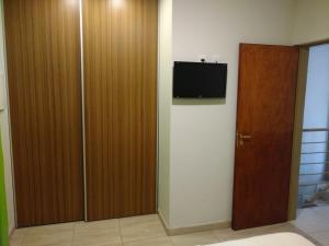 um quarto com uma porta e uma televisão na parede em Gala em Paso de los Libres